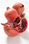 Three pomegranates, two whole and one halved