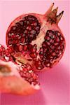 Pomegranate, halved, on pink background