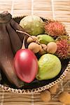 Basket of exotic fruit on straw mat