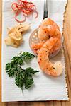 Garlic prawns on slotted spoon, ingredients beside it