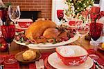 Roast turkey on Christmas table in front of fireplace