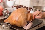 Brushing turkey with marinade