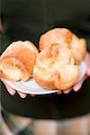 Woman holding plate of popovers