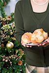 Woman holding plate of popovers (Christmas)