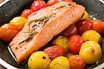 Fried salmon fillet and cherry tomatoes in frying pan