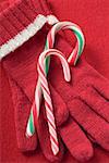 Two candy canes on red gloves