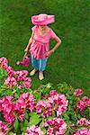 Femme en due forme chapeau rose festive dans le jardin