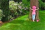 Woman in festive pink hat hugging tree