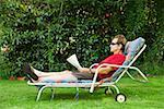 Man relaxing in lounge chair in backyard