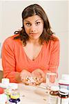 Woman holding handful of vitamins and supplements