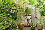 Woman sitting in backyard greenhouse