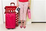 Woman standing with matching polka dot patterned suitcases