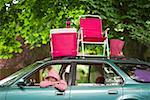 Woman sitting in car with picnic set on top
