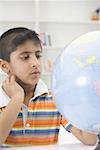 Boy looking at a globe