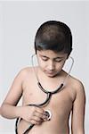 Close-up of a boy checking his heart rate with a stethoscope