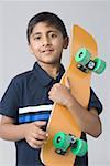 Portrait of a boy holding a skateboard
