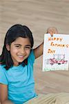 Portrait of a girl showing a greeting card