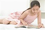 Close-up of a girl reading a book and smiling