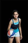 Portrait of a teenage girl playing with a basketball