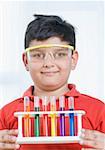 Close-up of a boy holding a test tube holder