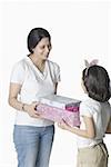 Mid adult woman giving gifts to her daughter