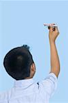 Rear view of a boy playing with a model airplane