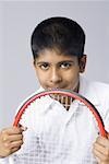 Portrait of a boy holding a tennis racket with his hands