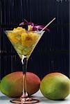 Close-up of a glass of mango slices and melon slices with mangoes