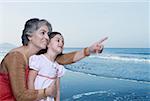 Close-up of a mature woman pointing and her granddaughter looking there