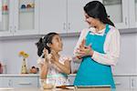 Mid femme adulte avec sa fille, préparation de la nourriture dans la cuisine