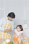 Young man looking at his daughter preparing food