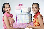 Portrait of a teenage girl holding gifts with her sister