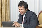 Businessman using a personal data assistant and smiling