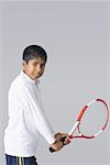 Portrait d'un garçon tenant une raquette de tennis