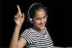 Portrait of a teenage girl listening to music with headphones and dancing