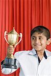 Boy holding a trophy and smiling