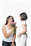 Side profile of a girl with her mother holding a bunch of flowers