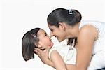 Side profile of a young woman and her daughter rubbing their noses and smiling