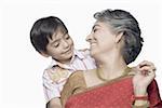 Close-up of a mature woman and her grandson looking at each other and smiling