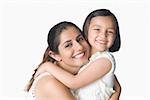 Portrait of a young woman hugging her daughter and smiling