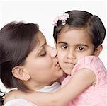 Close-up of a mid adult woman kissing her daughter