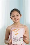 Portrait d'une jeune fille montrant son dessin et souriant