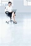 Porträt einer geschäftsfrau, die mit einem Laptop in einem Büro