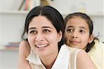 Close-up of a girl hugging her mother from behind