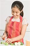 Close-up of a girl cutting cucumber with a knife