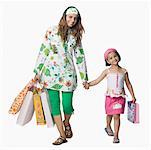 Portrait of a young woman with her daughter holding shopping bags and smiling