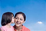 Close-up of a girl kissing her mother