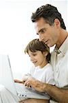 Père et fils ensemble à l'aide d'ordinateur portable