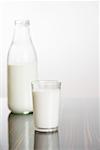 Glas Milch, Milchflasche im Hintergrund