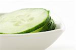 Cucumber slices piled in small dish, close-up